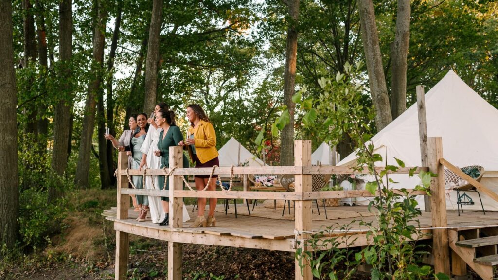 Lakecroft Glamping Bachelorette Party. Bachelorettes standing on the deck of the glamping tent overlooking the marshland