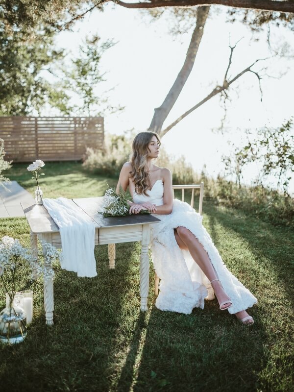 Bride sitting down at the signing table at the Lakecroft ceremony side gazing out onto the lake