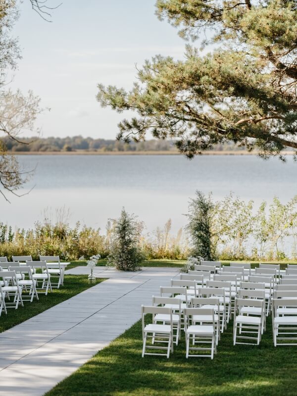 Lakecroft ceremony site on the lake setup with chairs and wedding arch