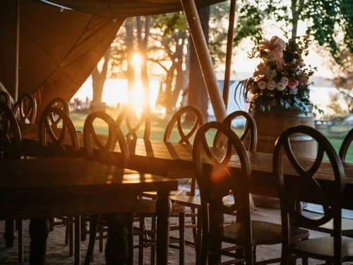 Nordic tent setup for a wedding looking outside to sunset over the lake